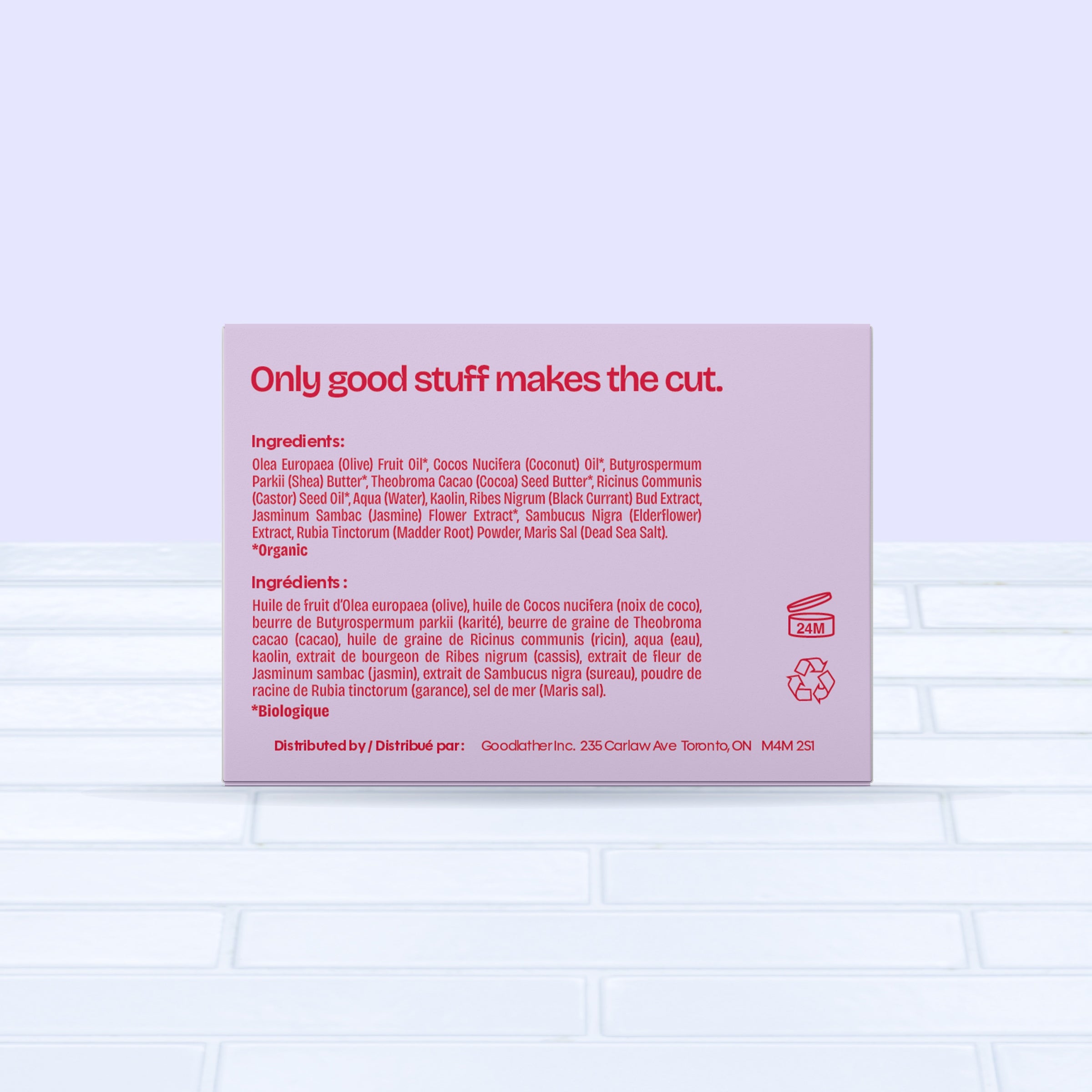 A bold red & pink Goodlather Black Currant and Jasmine Bar Soap box displays ingredients in English and French, with Only good stuff makes the cut. in bold red at the top. The sustainable, all-natural bar sits on light tile with a pale blue background.