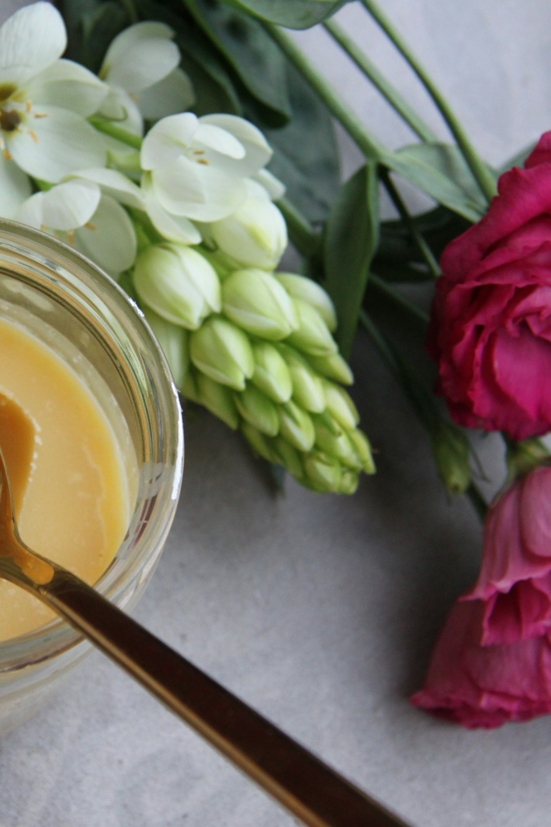 A jar of creamy shea butter with a wooden spoon
