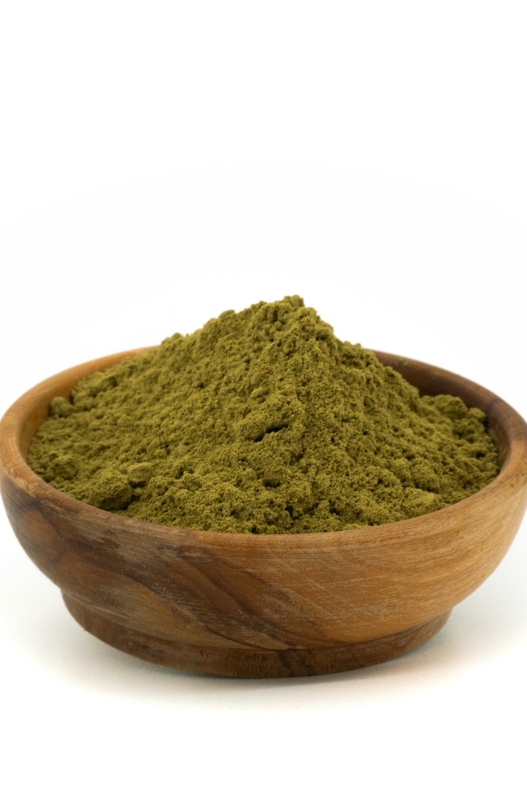 Green clay powder in a wooden bowl