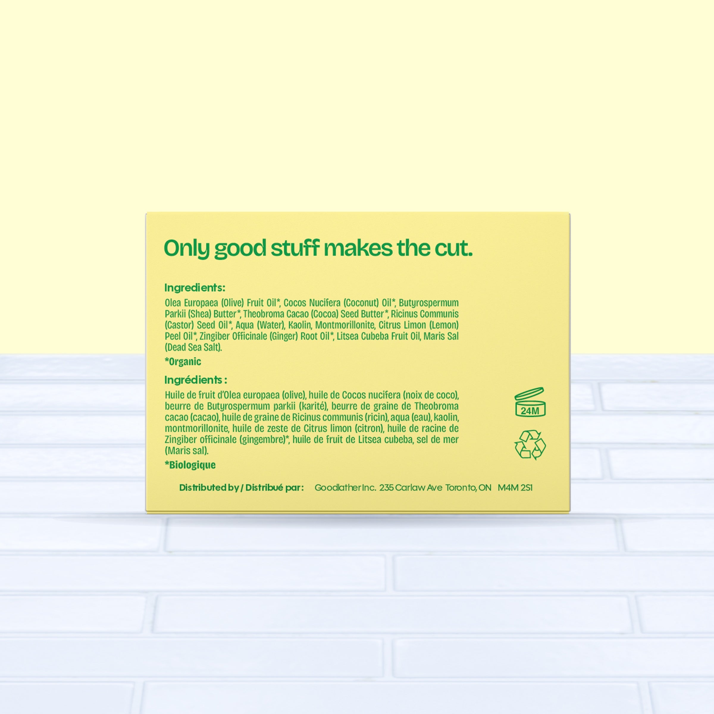 A bright yellow and green Goodlather Lemongrass and Ginger Bar Soap box sits on a light blue surface, showing ingredients in English and French, green text “Only good stuff makes the cut,” and eco-friendly icons for recycling and 24-month shelf life.